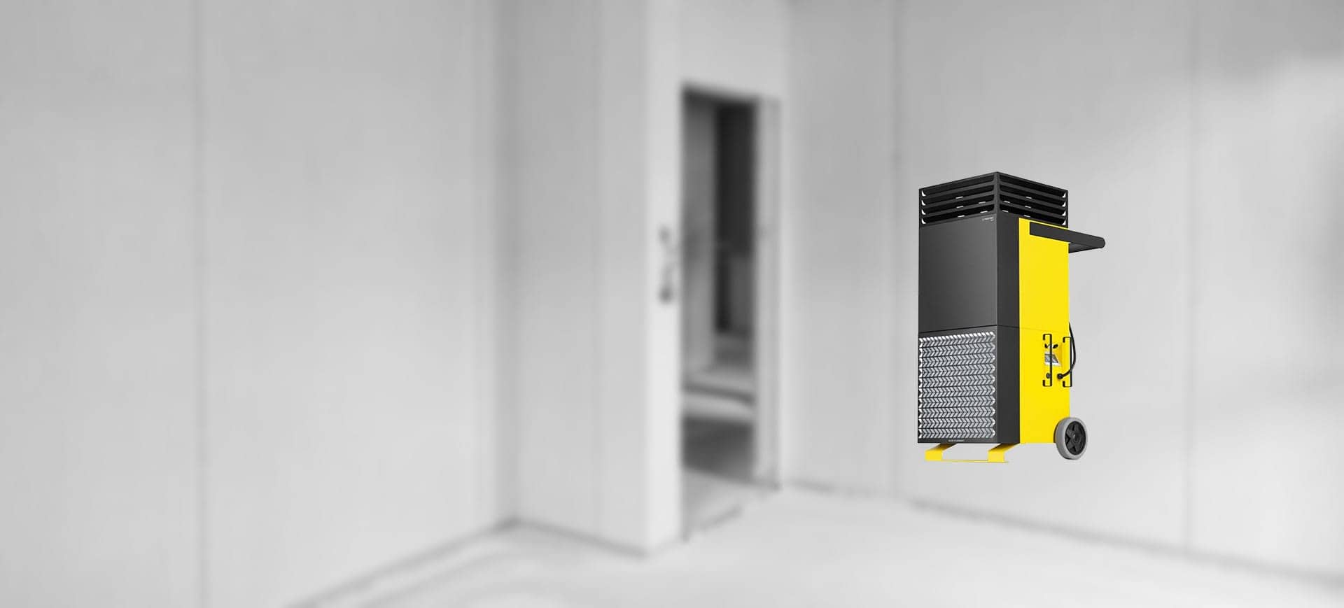 Gelb-schwarzer mobiler Luftreiniger mit Virenfilter auf Rollen in leerem Raum – leistungsstarkes Gerät zur Staub- und Schadstofffilterung auf Baustellen.